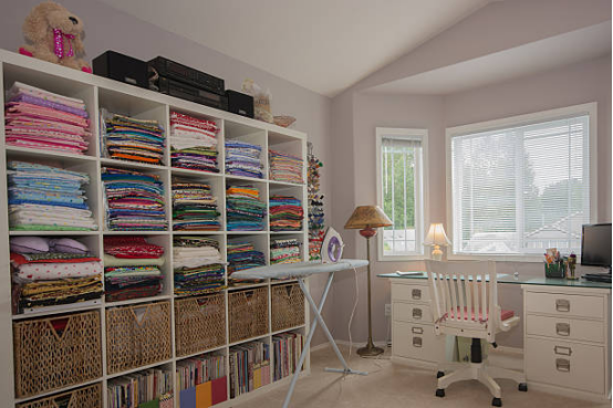 Height-adjustable ironing board for comfortable quilting and sewing setup.