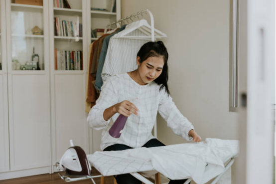 Spraying fragrance evenly on clothes during ironing process.