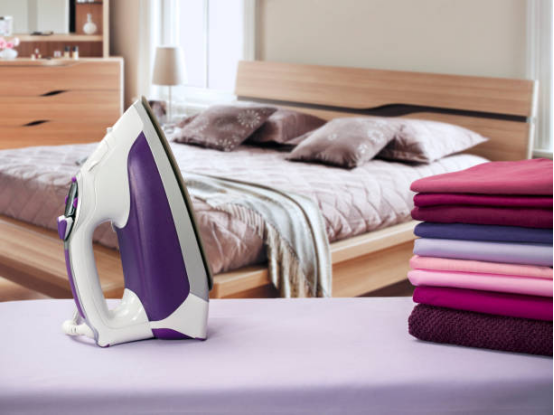 Ironing wide-shouldered coat on a sturdy ironing board
