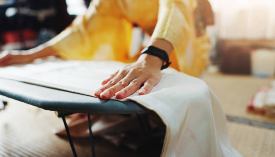 Adjusting garment shape on ironing board for perfect finish