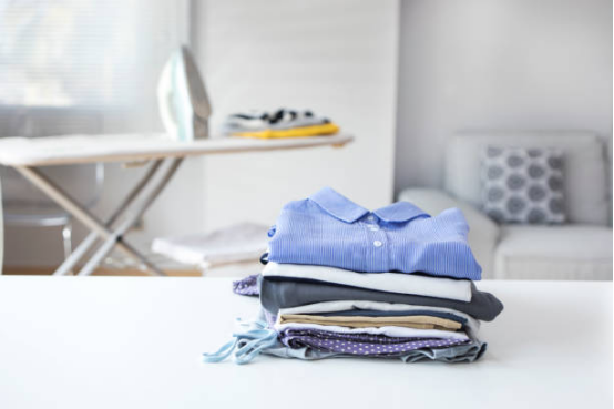 A hand quickly deploying an integrated, pull-out ironing board in a closet area.