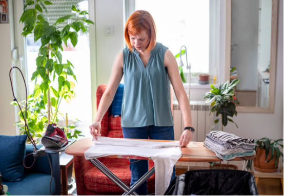 How Ironing Boards Influence Ironing Habit Formation 1 User adjusting an ironing board for easy use
